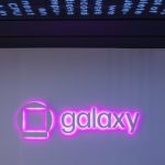 Galaxy logo sign illuminated by neon pink light glowing beneath the sign.